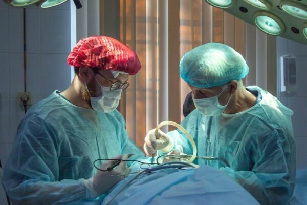 two men wearing blue lab coats